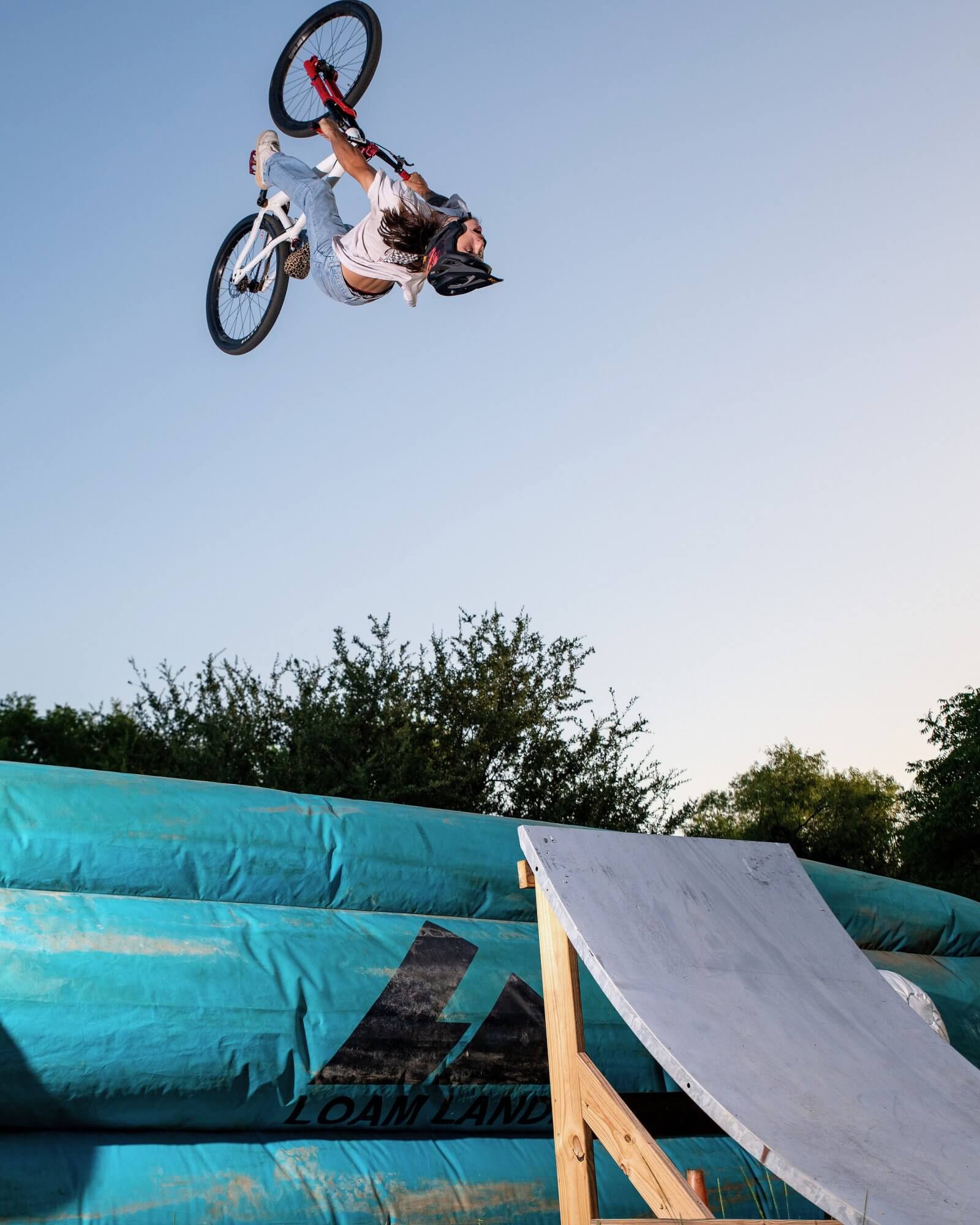 BMX rider practicing an aerial trick over the resi air bag at Alliance Skatepark in Grand Prairie.