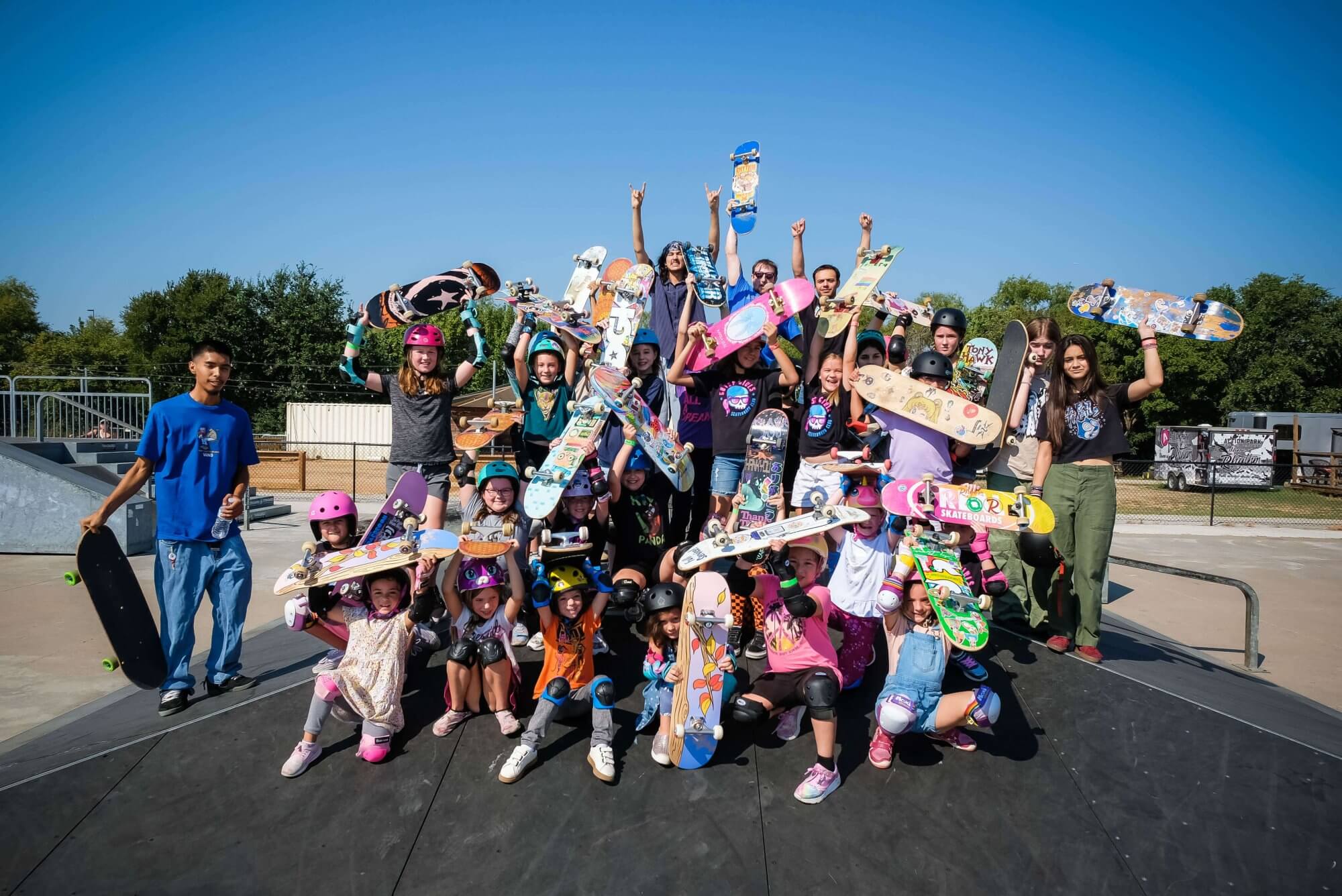 Group of young skateboarders holding skateboards at Alliance Skatepark.
